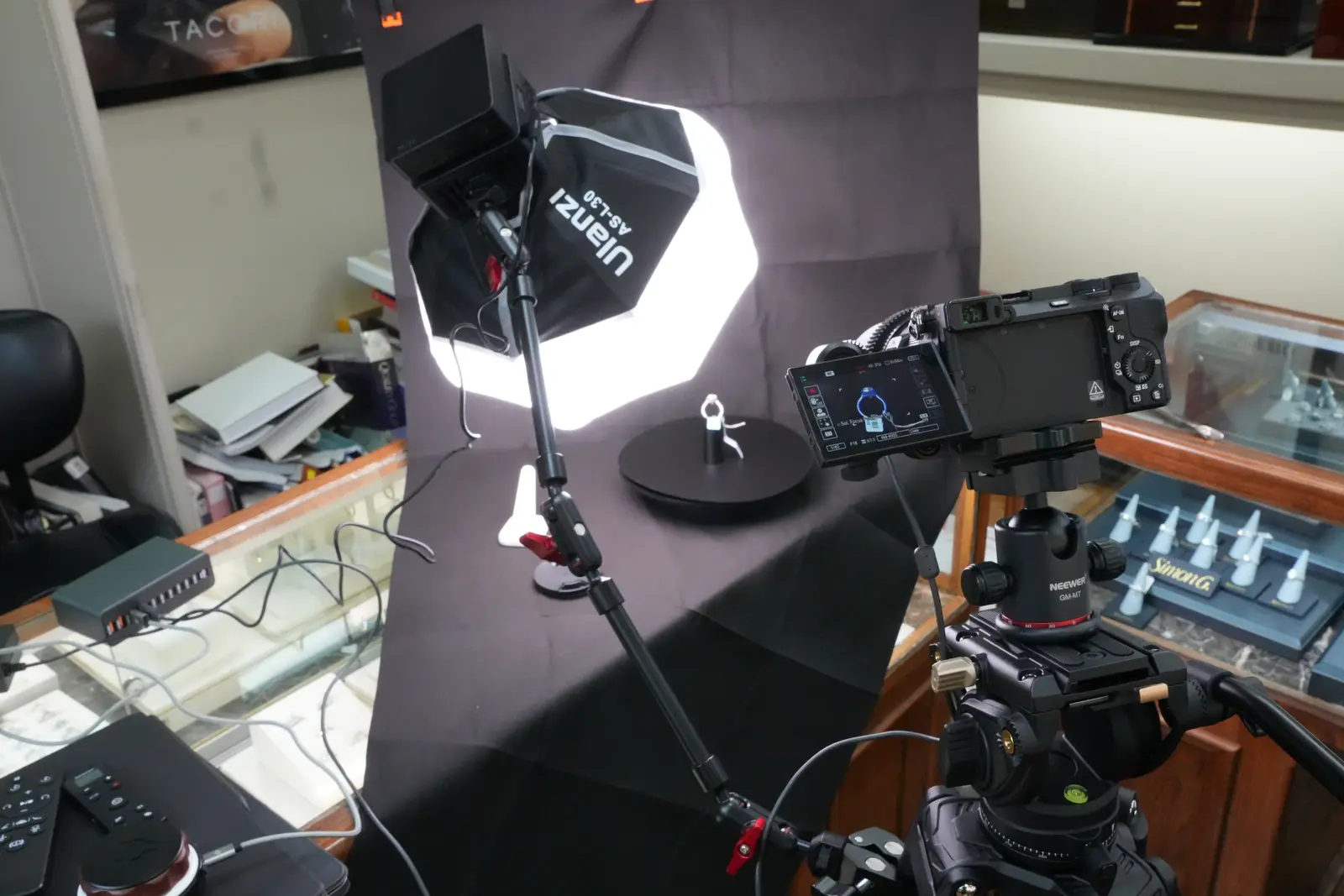 Camera with a monitor and a round softbox lighting a ring on a turntable at O'Neal's Jewelers