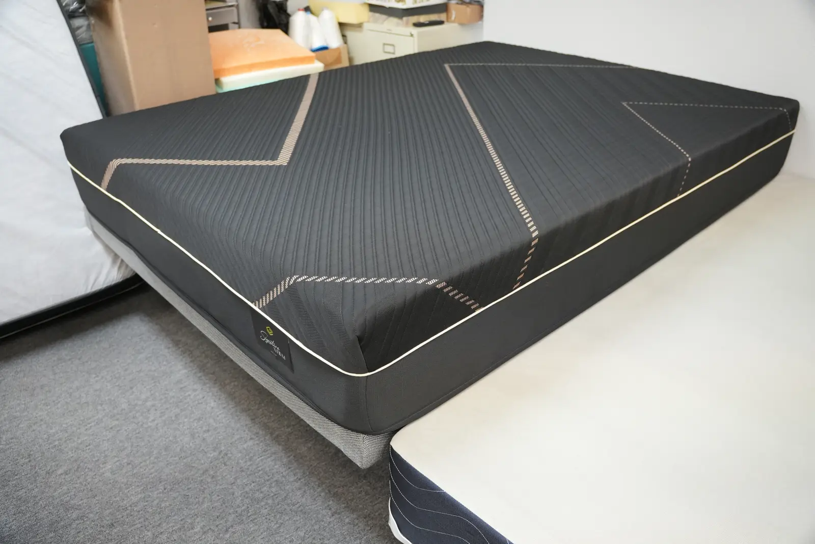 Charcoal gray foam mattress with gold piping on the Golden Mattress showroom floor