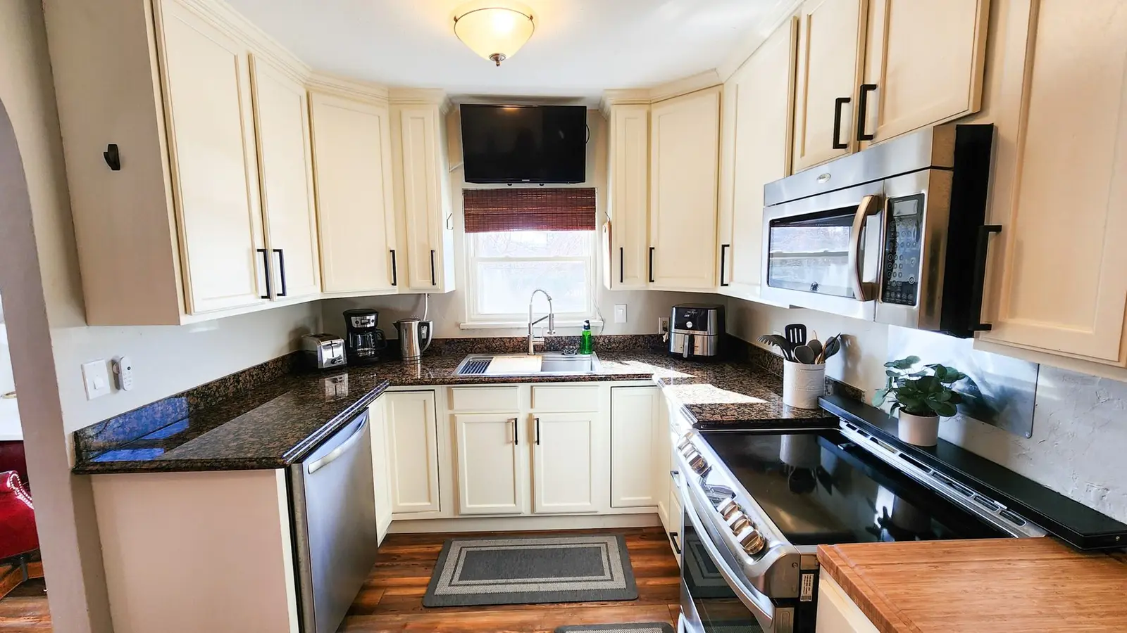 The Elati House kitchen with cream cabinets, granite counters and stainless appliances