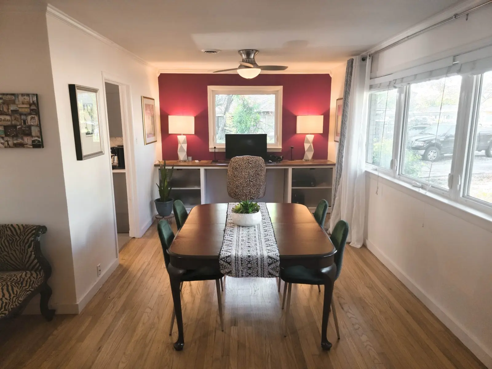 The McCosh House dining room with a wood table and a red accent wall